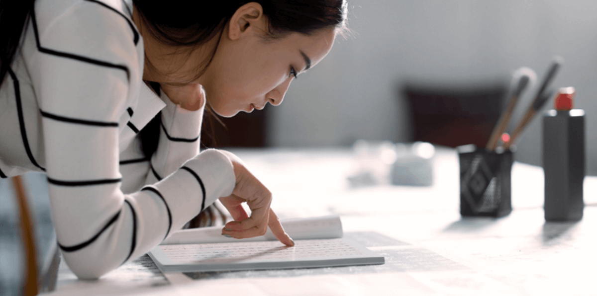 Photo of woman reading at a desk