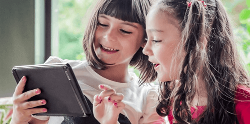 Two young girls using a tablet