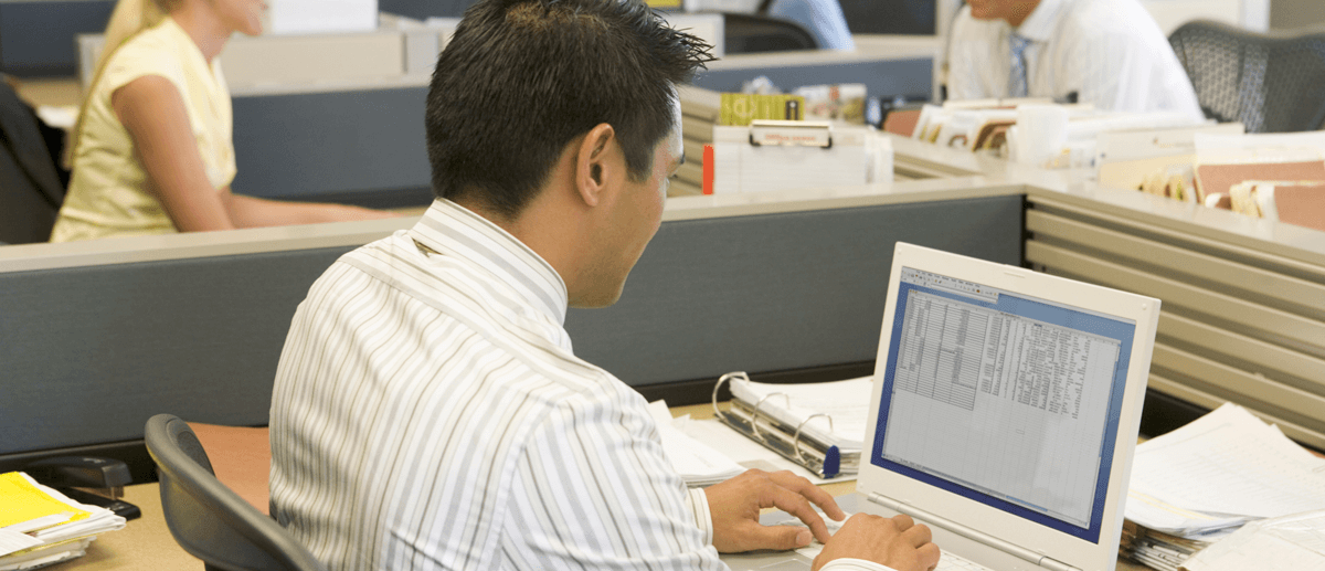 Young man working on a computer in a cubicle